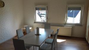 a dining room with a table and chairs and two windows at Gaststätte Molitor in Saarlouis