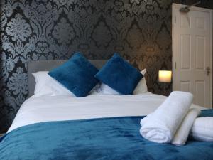 ルートンにあるLyndhurst Houseのベッドルーム1室(青と白の枕が備わるベッド1台付)