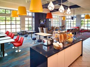 a restaurant with tables and chairs and yellow lights at LivINN Hotel St Paul East / Maplewood in Maplewood