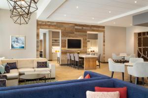 a living room with blue couches and a dining room at Hyatt Place Niagara Falls in Niagara Falls