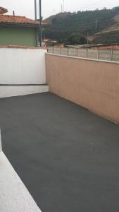 an empty parking lot next to a wall at Casa de Família in Capitólio