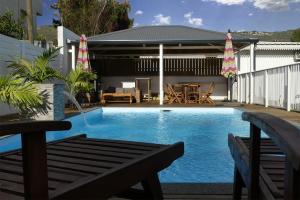 a swimming pool with a bench and a table at Cote Plage in La Saline les Bains