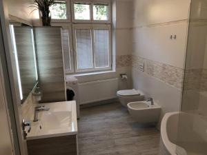 baño con 2 lavabos, aseo y ventana en Luxusní apartmán přímo v centru u hotelu Thermal en Karlovy Vary