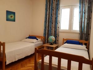 1 Schlafzimmer mit 2 Betten, einem Fenster und einem Globus in der Unterkunft Apartments Krizanac in Trogir