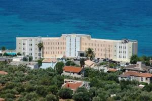 an aerial view of a large building near the ocean at Messinian Bay in Kalamata