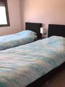 two beds sitting next to each other in a bedroom at oasis beach casa Georgio in Guardamar del Segura