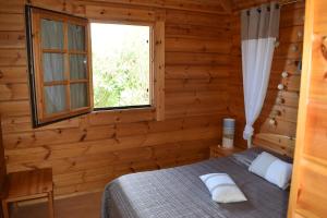 a bedroom with a bed and a window at "Belle maison en bois" in Messanges