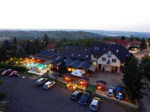 une vue aérienne sur une maison avec des voitures garées sur un parking dans l'établissement Vándor Vigadó, à Zalaegerszeg