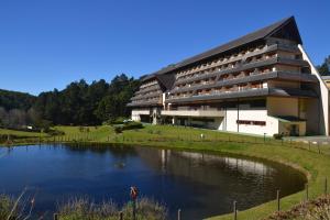 a building with a lake in front of it at Satélite - Campos do Jordão in Campos do Jordão