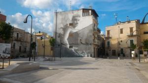 a mural of a man on the side of a building at La Numaba in Corato