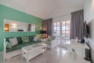 a living room with a green couch and a table at Club Vista Serena in Maspalomas