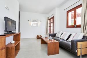 un soggiorno con divano e TV di Villa Can Kiva a Es Cubells