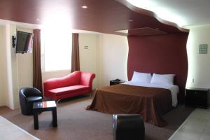 a hotel room with a bed and a red chair at Motel Septimo Eclipse in Acolman de Netzahualcóyotl