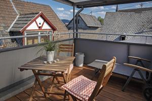einen Holztisch und Stühle auf dem Balkon in der Unterkunft Haus Mittelrhein in Rhens