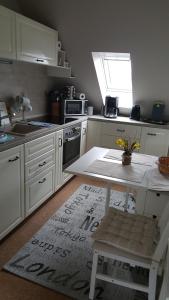 a kitchen with white cabinets and a table and a window at Haus Ginkgo in Kappeln