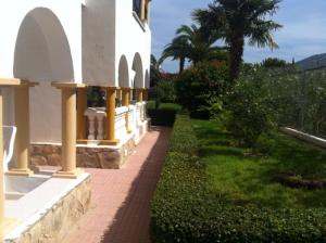 a brick walkway next to a building with a palm tree at Casas Blancas Bungalow 45 in L’Alfàs del Pi