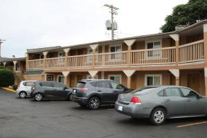 tres autos estacionados en un estacionamiento frente a un motel en Battlefield Inn Springfield, en Springfield