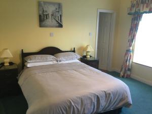 Un dormitorio con una cama grande y una ventana en Colonelwood House, en Westport