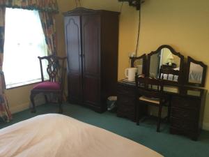 a bedroom with a dresser and a mirror and a bed at Colonelwood House in Westport +15 photos