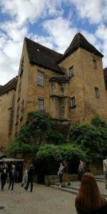 un grupo de personas caminando frente a un gran edificio en Les farios, en Sarlat-la-Canéda