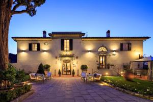 una gran casa blanca con patio por la noche en Villa Il Sasso - Dimora d'Epoca, en Bagno a Ripoli