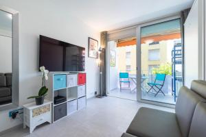 a living room with a couch and a tv at Beautiful studio near sea (free parking) in Roquebrune-Cap-Martin