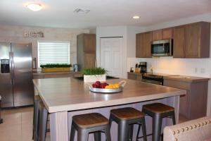 a kitchen with a island with a bowl of fruit on it at Latitude 26 Waterfront Boutique Resort - Bonita Springs in Bonita Springs