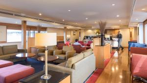 a hotel lobby with couches and tables and people at Millennium Hotel Rotorua in Rotorua