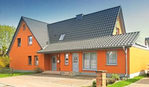 een oranje huis met een zwart dak bij Ferienwohnung Zander in Zingst