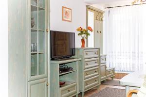 a living room with a tv and a dresser at Ferienwohnung Zander in Zingst