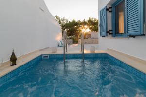 a swimming pool in front of a house at Gina's Cozy House in Kamilari