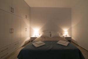 a bedroom with a bed with two towels on it at Gina's Cozy House in Kamilari +21 photos