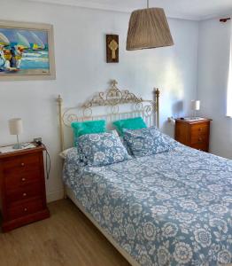 a bedroom with a bed with a blue comforter and pillows at CAMELIA Casina Rural in Albuerne