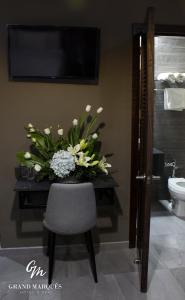 eine Vase mit Blumen auf einem Tisch im Bad in der Unterkunft Grand Marques in San Juan de los Lagos
