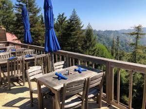 einen Holztisch mit Stühlen und Sonnenschirmen auf einer Terrasse in der Unterkunft Mountain Home Inn in Mill Valley