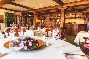 uma sala de jantar com mesas e toalhas de mesa brancas em Hotel Löwen em Eggenstein-Leopoldshafen