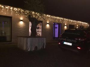 a car parked in front of a building with christmas lights at B&B Maison Beau in Zonhoven