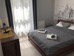 una camera da letto con un letto e due asciugamani di Mieszkanie w Riverside w centrum Starego Miasta a Danzica