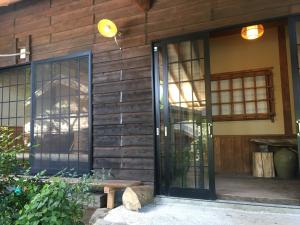 湯布院的住宿－山荘 紗羅樹 Syaranoki，木房子的入口,设有玻璃门