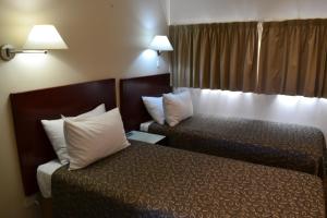 a hotel room with two beds with white pillows at Lufra Hotel and Apartments in Eaglehawk Neck
