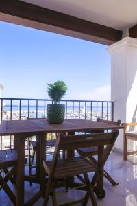 a table on a balcony with a potted plant on it at Duquesa Seaview marina in Manilva