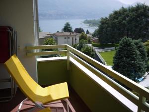 une chaise jaune sur un balcon avec vue dans l'établissement Casa Rabissale, à Locarno