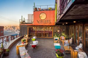 a balcony of a building with tables and chairs at Hotel Winebox Valparaiso in Valparaíso