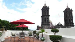 a patio with tables and chairs and two towers at Hotel Santiago in Puebla
