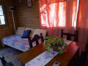 una habitación con una mesa y una cama en una cabaña en Cabaña mandala, en Tigre