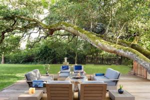 patio con sedie e tavolo sotto un albero di Gaige House a Glen Ellen