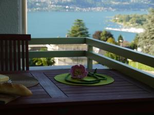 a plate with a flower on a table with a view at Casa Rabissale in Locarno +11 photos