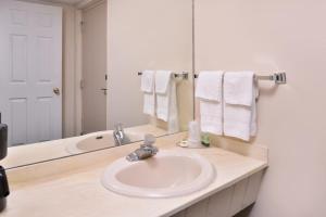 a white sink sitting under a mirror in a bathroom at Red Carpet Inn in Worthington