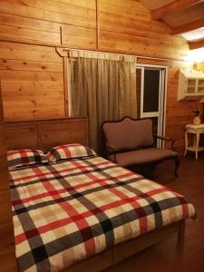 鹿谷的住宿－溪頭紅瓣天民宿，小屋内一间卧室配有一张床和一把椅子