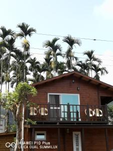 鹿谷的住宿－溪頭紅瓣天民宿，带阳台和棕榈树的房子